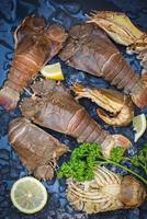 Raw flathead lobster shrimps on ice, fresh slipper lobster flathead for cooking with herbs and spices parsley lemon in the seafood restaurant or seafood market, Rock Lobster Moreton Bay Bug photo
