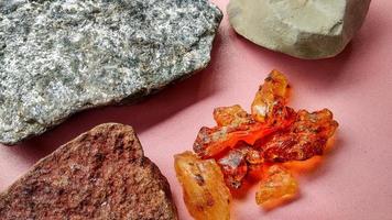 Resin sap is a natural sap from the Agathis borneensis tree, yellow light from central java, Indonesia. Isolated with scistmica, napal and chert, marl from geological collection rock, pink background. photo