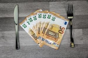 Billetes de 50 euros con tenedor y cuchillo foto