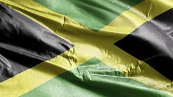 bandera textil jamaica ondeando en el bucle de viento. bandera jamaicana balanceándose en la brisa. tejido textil tejido. fondo de relleno completo. Bucle de 10 segundos. video