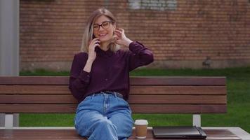 Business Woman talking on mobile phone outdoor on urban street park. video