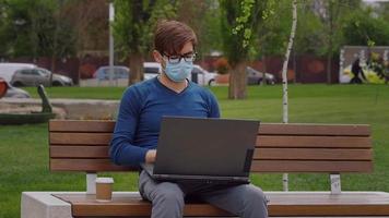 jonge professionele freelancer die een chirurgisch gezichtsmasker draagt, video