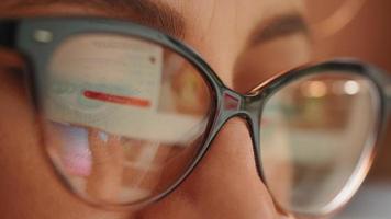 Woman shopping online, reflection in glasses of the hands and credit card making e bank online payment. video