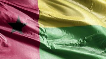 Guinea-bissaus textilflagga vajar på vindslingan. Guinea-bissau banderoll vajande på vinden. tyg textilvävnad. full fyllning bakgrund. 10 sekunders loop. video