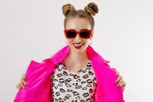 Happy, shock, excited woman face closeup. Girl in bright pink autumn clothes, red sunglasses isolated on white background, copy space. Beautiful female surprised, cheerful. Fun funny model screaming photo