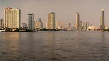 lasso di tempo 4k durante la sera, grattacielo sul lungomare nel cuore di bangkok. video