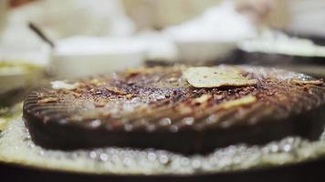 cerdo asado en una sartén llena de sartenes chamuscados en el restaurante. video