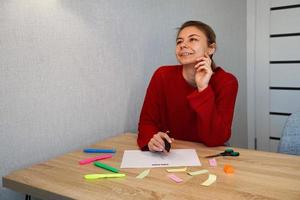 retrato de una joven hermosa dama pensativa escribiendo su lista de sueños foto