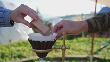 as pessoas adicionam grãos de café moídos no gotejador para fazer café expresso de manhã video