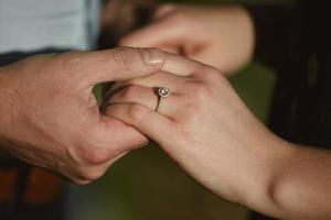 dos amantes, una pareja, un niño y una niña están tomados de la mano. la niña en su mano es un anillo de bodas. el concepto de amor foto