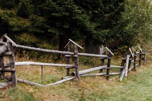 old wooden rural fence in the mountains of a beautiful autumn day photo