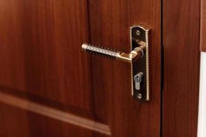 Modern style door handle on natural wooden door photo