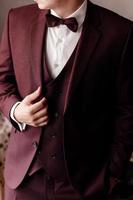 hombre con un elegante esmoquin marrón con corbata de lazo de seda y reloj. enfoque selectivo. foto