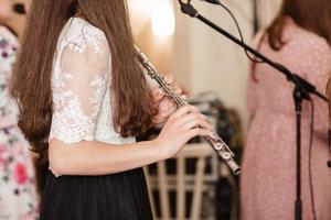 flautista, niña tocando la flauta, manos, dedos en las teclas de cerca, niños tocando la flauta lateral transversal, toma detallada, música clásica, intérprete de instrumentos de viento de cerca resumen foto