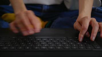 mujer escribiendo en el teclado del portátil en casa.