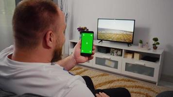 homem conversando com um amigo em uma tela verde de smartphone de chamada de vídeo e chroma key. video
