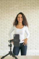 Latin woman created her dancing video by smartphone camera. To share video to social media application. photo