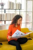 Latin America woman reading newspaper on sofa photo