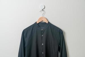 hanging shirt with wood hanger on wall photo