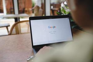 bangkok tailandia 3 de febrero de 2022 un hombre está escribiendo en el motor de búsqueda de google desde una computadora portátil. Google es el motor de búsqueda de Internet más grande del mundo. foto