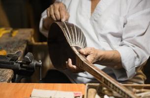 maestro adulto restaura instrumentos musicales antiguos. producción de instrumentos de cuerda foto