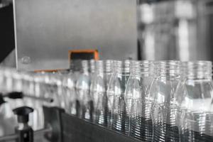 botellas de plástico vacías en la cinta transportadora. equipo en la planta de productos lácteos foto