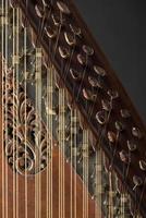 ancient Asian stringed musical instrument on black background with backlight. the similarity of the harp and psaltery. closeup photo