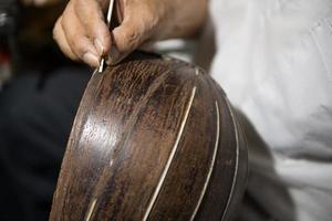 adult master restores old musical instruments. wood carving photo