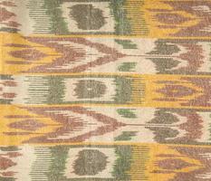 Background from the tissue with oriental ornaments and multi colored pattern, textile photo