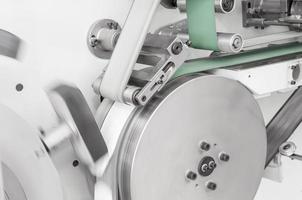 equipment and mechanism with a moving cloth tape on rollers closeup. in the production of moving fabric tape on network rollers photo