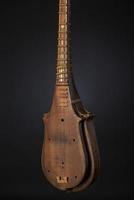 part ancient Asian stringed musical instrument on black background with backlight photo