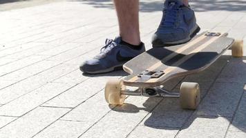 junge steht auf einem skateboard und fährt im sommertag auf der stadtstraße