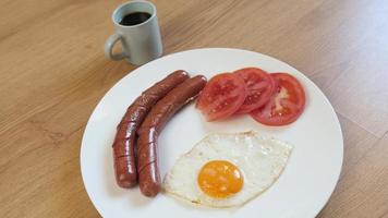 teller mit essen, frühstücksei, tomate, würstchen und tasse kaffee espresso video