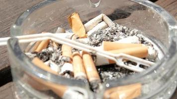 Tabakaschenbecher mit geräucherten Zigaretten und Filtern video