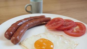 bord eten, ontbijtei, tomaat, worstjes en kopje koffie espresso video