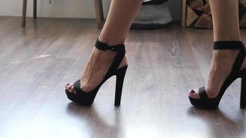 pernas de mulher vêm devagar em sapatos de salto alto em uma sala video