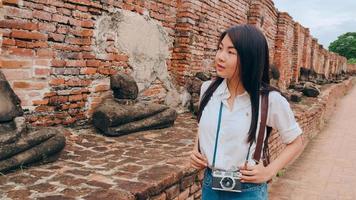 mujer asiática viajera que pasa un viaje de vacaciones en ayutthaya, tailandia, mujer mochilera japonesa disfruta de su viaje en un hito increíble en la ciudad tradicional. concepto de vacaciones de viaje de mujeres de estilo de vida. foto