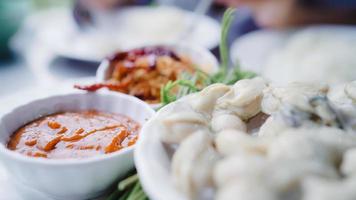 Young Asian woman eating oyster seafood in restaurant, teenager female feeling happy eating food. Women eating seafood concept. photo