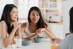 las mujeres asiáticas desayunan en casa, un grupo de jóvenes amigas de asia que se sienten felices y divertidas hablando juntas mientras desayunan en la cocina en el concepto de la mañana. foto