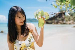 Beautiful young Asian woman happy relax walking on beach near sea. Lifestyle women travel on beach concept. photo