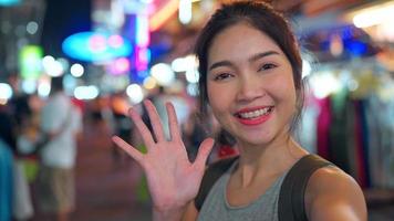 Traveler Asian blogger woman travel in Bangkok, Thailand, beautiful female using mobile phone make vlog and live in social media while hangout at The Khao San Road. Women travel in Thailand concept. photo