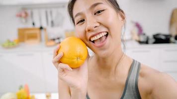 una bloguera asiática hace un vlog sobre cómo hacer dieta y perder peso, una joven india que usa una grabación de teléfono inteligente cuando come frutas de manzana en la cocina. Concepto de comida saludable para mujeres influyentes en el estilo de vida.