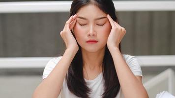 Asian student women read books in library at university. Young undergraduate girl stress tired have problem while study hard for knowledge on lecture desk at college campus concept. photo