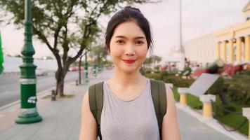 Traveler Asian woman feeling happy smiling to camera holiday trip at Bangkok, Thailand, backpacker Asia female enjoy their journey at amazing landmark in traditional city. Portrait looking at camera. photo