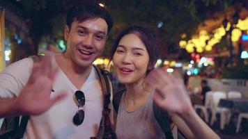 Traveler Asian blogger couple travel in Bangkok, Thailand, sweet couple using mobile phone make vlog and live in social media while hangout at The Khao San Road. Couple travel in Thailand concept. photo