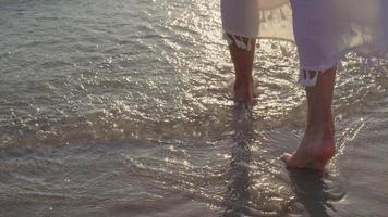 Young Asian woman walking on beach. Beautiful female happy relax walking on beach near sea when sunset in evening. Lifestyle women travel on beach concept. photo