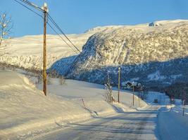 Driving at sunrise through mountains and forests in Norway. photo