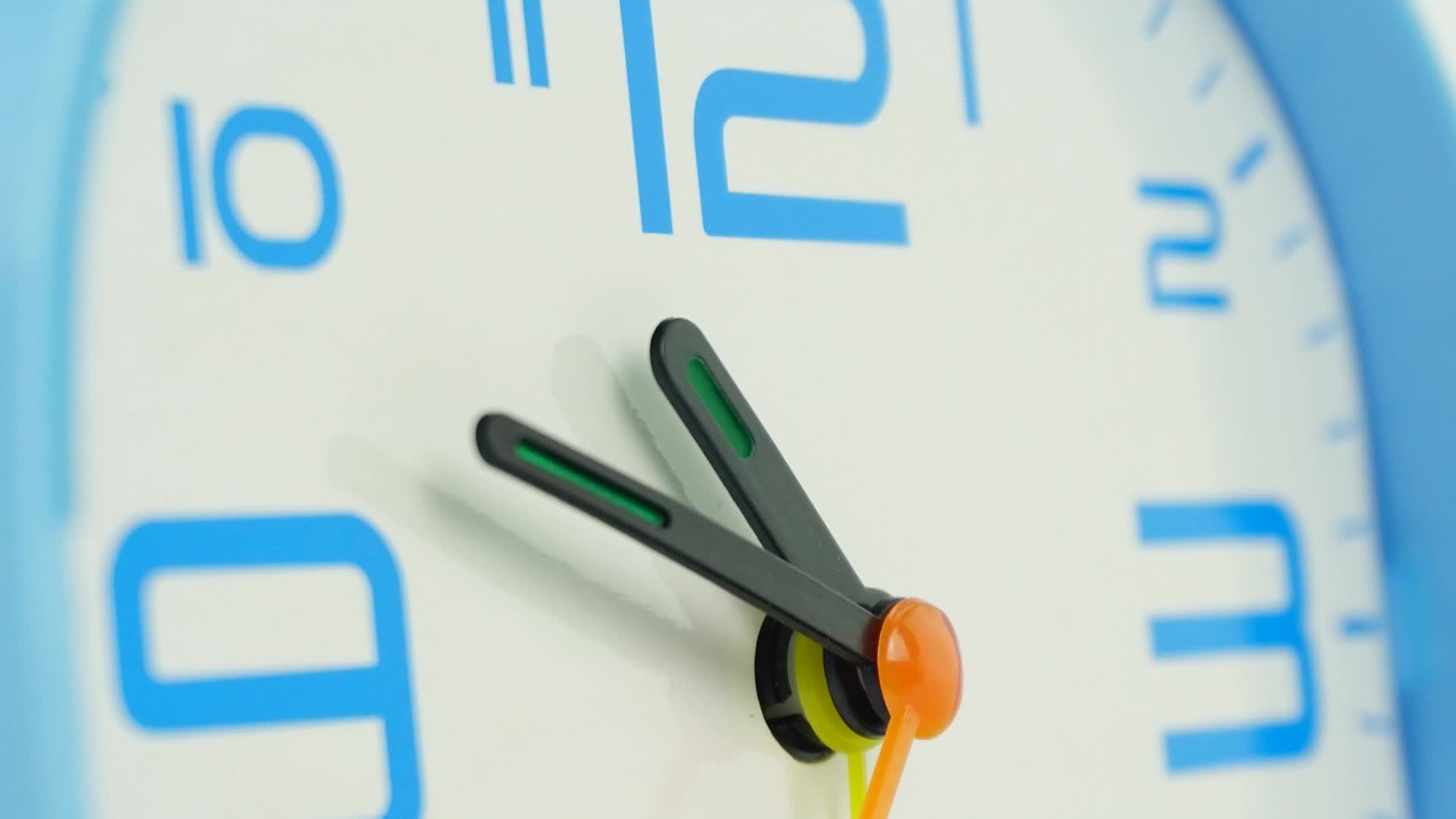 Time lapse blue alarm clock tells the time at 11 o'clock. Shows the
