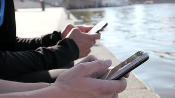 Outdoors Hands only Of Two Boys Friends Using Mobile Phone on City Quay video