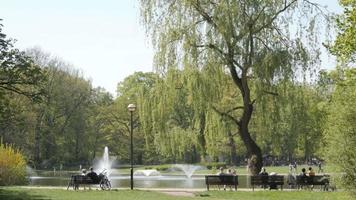 Spring Park of Wroclaw Poland. People relax on a Bench and walk along the Lake video